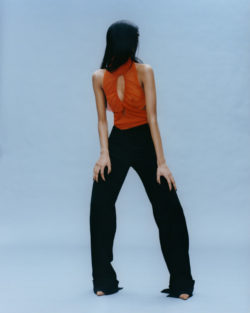 Model met oranje top en zwarte broek, ontwerp van Supriya Lele uit de collectie herfst-winter 2021-2022