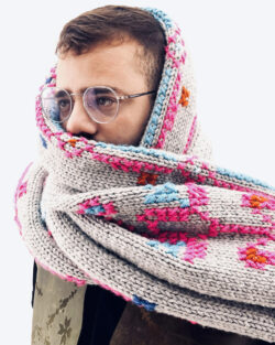 Portret van een man: hij draagt een bril en zijn gezicht is bedekt met een gebreide sjaal