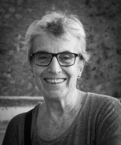 A woman with glasses and short hair poses for the camera
