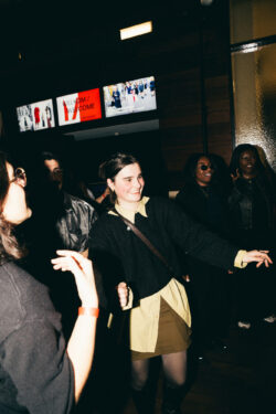A woman dressed in a black shirt is captured, highlighting her modern and chic fashion choice.