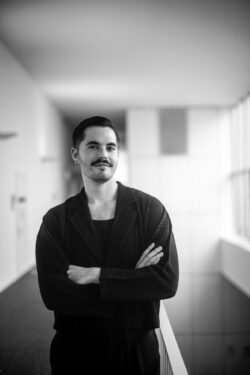 A man poses with his arms crossed for a portrait photo.