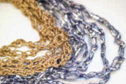 Detail of two necklaces in purple, silver and gold made with the Solomon's knot.