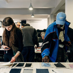 Mensen kijken naar stofstalen in de MoMu-bibliotheek