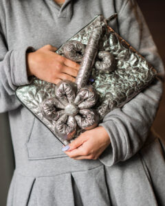 Een persoon houdt een clutch met een 3D-bloem vast