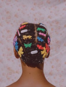 Eine Frau mit bunten Haarspangen im Haar.