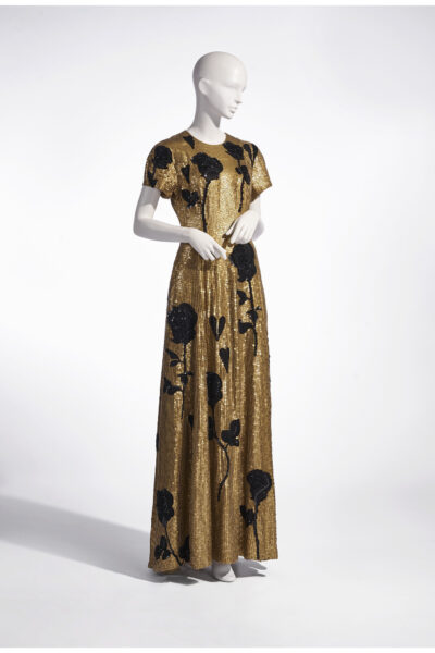 Silhouette by Bernadette with gold and black sequins in the shape of flowers.