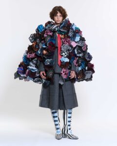 A model poses in clothing designed by Annaëlle Reudink in front of a white background